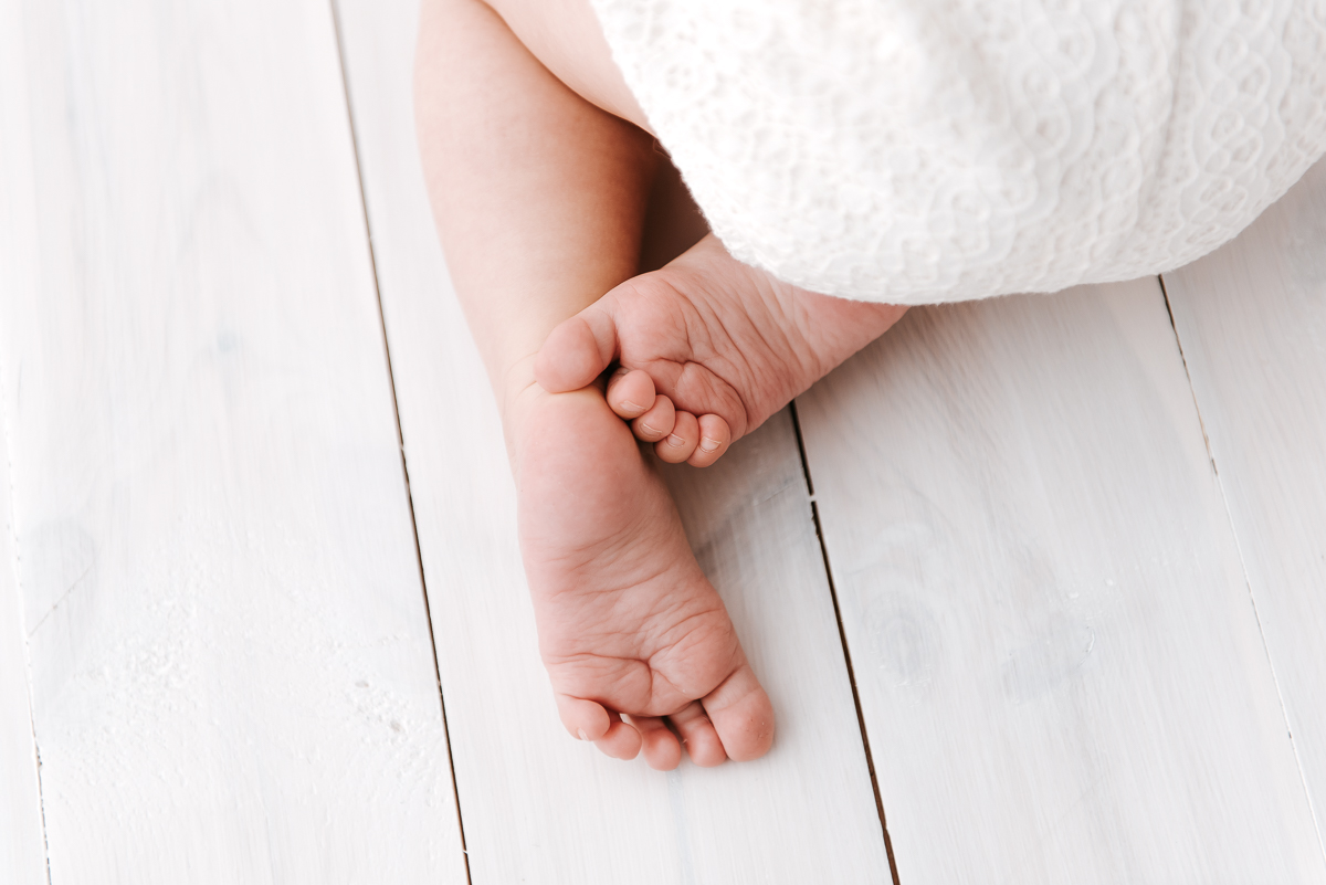 Zbliżenie stópek małego niemowlaka na sesji fotograficznej